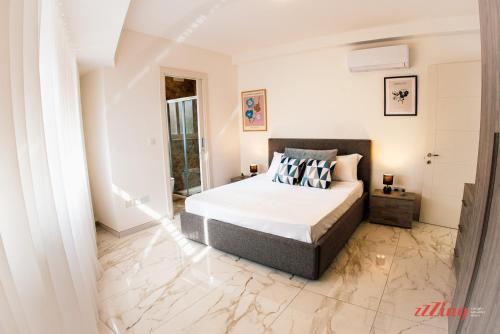 een slaapkamer met een bed en een marmeren vloer bij Mensija Valley Residences in St Julian's
