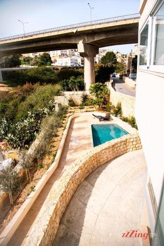 a swimming pool with a bridge in the background at Mensija Valley Residences in St Julian's