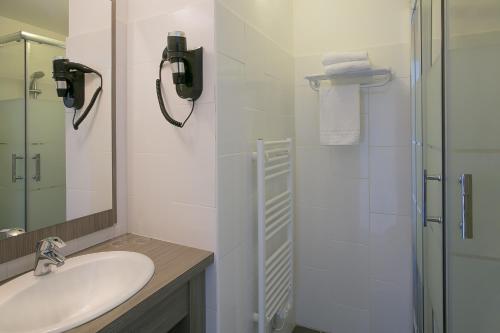 a white bathroom with a sink and a shower at Best Western Hôtel des Thermes - Balaruc les Bains Sète in Balaruc-les-Bains