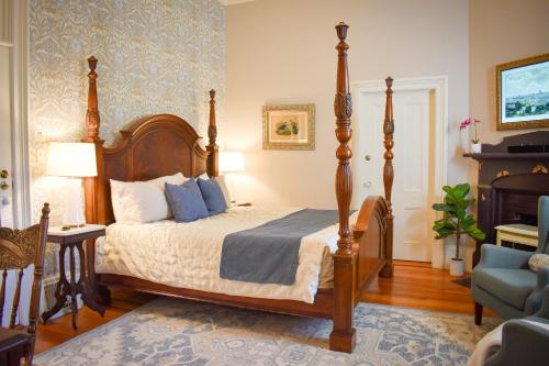 a bedroom with a large bed and a chair at McCall House Boutique Hotel in Ashland