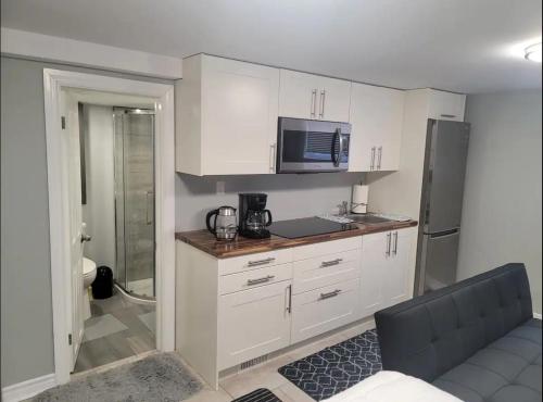 uma cozinha com armários brancos e um micro-ondas em Private Apartment in Ottawa near the Ottawa hospital em Ottawa