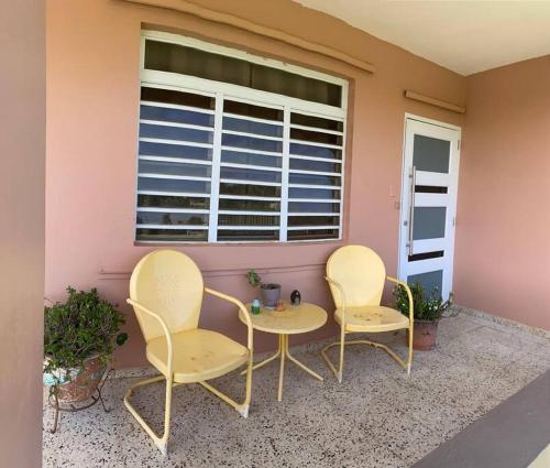3 sillas y una mesa frente a una ventana en Marie Guest House (A/C entire house), en Camuy