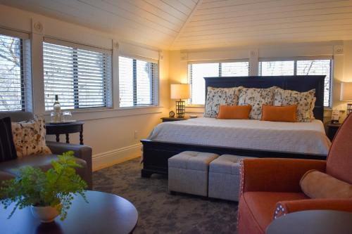 a bedroom with a bed and a couch and windows at McCall House Boutique Hotel in Ashland