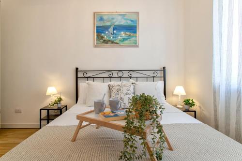a bedroom with a bed with a table with flowers on it at Delia's Home in Alghero