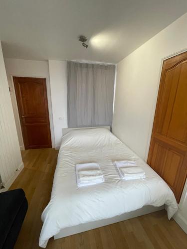 - un lit blanc avec 2 serviettes dans une chambre dans l'établissement Paris 5e arr Place Saint Michel, à Paris