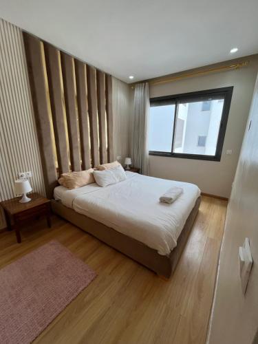 1 dormitorio con cama y ventana grande en Luxury appartement in Heart of Casablanca Maarif en Casablanca