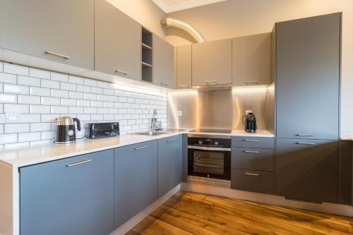 eine Küche mit Geräten aus Edelstahl und Holzböden in der Unterkunft Canto do Atlântico Loft (City Centre) in Ponta Delgada