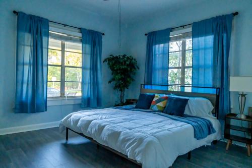 a blue bedroom with a bed with blue curtains at 5Beds-Walk to Bars and Shops-On Free Trolley Route in Tampa