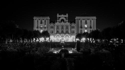 a large building lit up at night with a fountain at Curia Palace Hotel & Spa in Curia