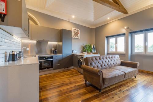 ein Wohnzimmer mit einem Sofa in der Küche in der Unterkunft Canto do Atlântico Loft (City Centre) in Ponta Delgada