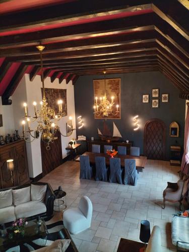 a living room with a couch and chairs and a chandelier at Chambres d'Hôtes Le Grismoustier in Veulettes-sur-Mer