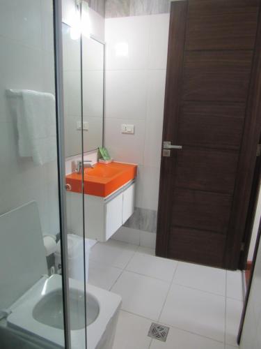a bathroom with an orange sink and a mirror at Departamento Jerry in Cochabamba