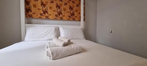a white bed with a folded towel on it at Casa Visto Mar in Sal Rei