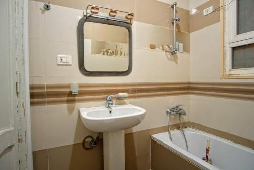 a bathroom with a sink and a bath tub at Cozy apartment in Sheikh Zayed, with private garden in 6th Of October