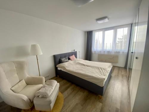 ein kleines Schlafzimmer mit einem Bett und einem Stuhl in der Unterkunft Luxusní Apartmá CHKO Třeboňsko in Veselí nad Lužnicí