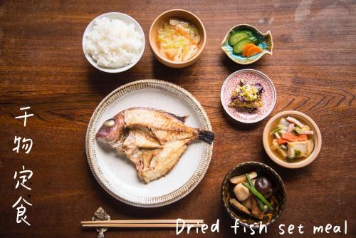 a table with a plate of food and bowls of food at Book & Guesthouse Hitotomaru in Toyooka
