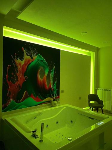 a bathroom with a tub with a painting on the wall at COLOMBO SUITE in Cassino