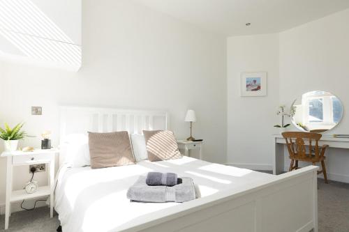 a white bedroom with a large white bed and a desk at ST MARYS APARTMENT - Modern Apartment in Charming Market Town in the Peak District in Penistone