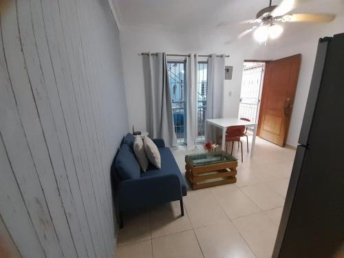 a living room with a blue couch and a table at J. B Apartamentos in Santo Domingo