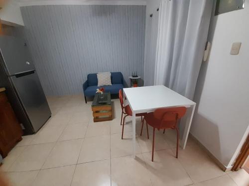 a living room with a white table and a blue couch at J. B Apartamentos in Santo Domingo