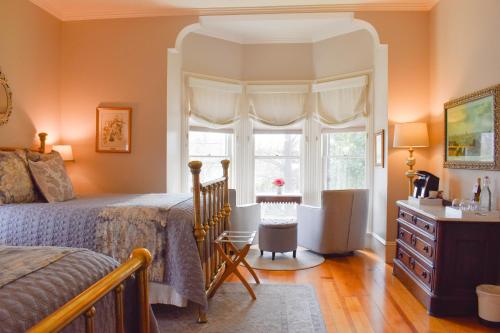 a bedroom with a bed and a window and a dresser at McCall House Boutique Hotel in Ashland