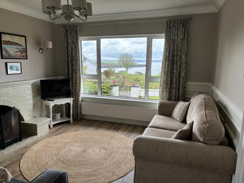 uma sala de estar com um sofá e uma grande janela em Seaview Bungalow em Donegal