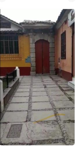 un edificio con una puerta roja al lado de una acera en Cuartos a 1 cuadra de la plaza de armas en Ayacucho