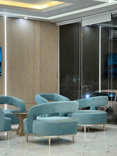 a waiting room with blue chairs and tables at ضيف بارك للشقق المخدومة in Ad Dawādimī