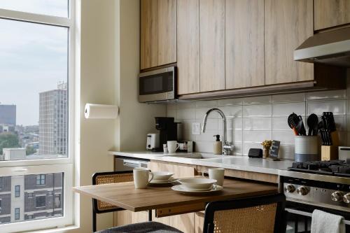 eine Küche mit einem Tisch, einem Waschbecken und einem Fenster in der Unterkunft Flexhome River West Studio N6 with Gym and Rooftop - READ INFO in Chicago