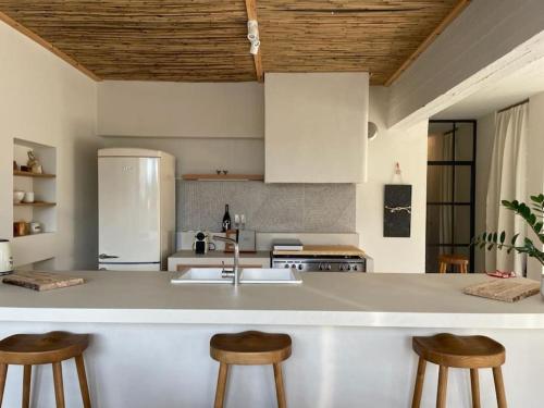 a kitchen with a sink and two bar stools at Casa Massina in Áno Poróïa
