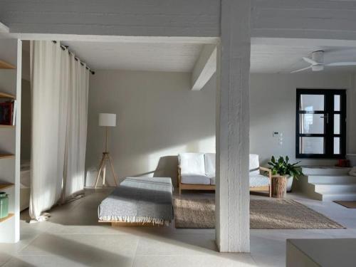 ein weißes Wohnzimmer mit einem Sofa und einem Tisch in der Unterkunft Casa Massina in Ano Poroia