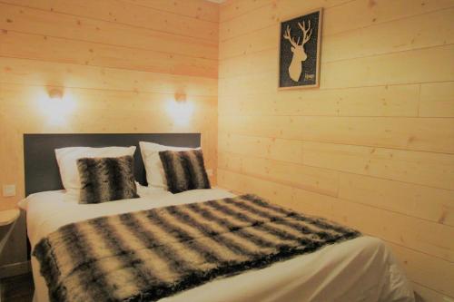 une chambre avec un lit dans un mur en bois dans l'établissement Val thorens appartement 2 ch avec belle vue sud, à Val Thorens