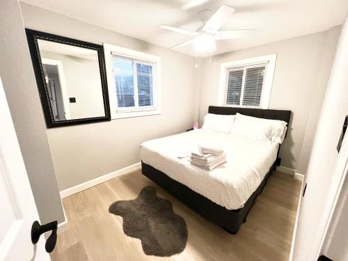 ein kleines Schlafzimmer mit einem Bett und einem Deckenventilator in der Unterkunft Seaside Serenity: Cozy Retreat on Bay Drive in Kill Devil Hills
