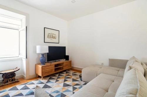 a living room with a couch and a tv at Cosy house for Surf & Beach in Esmoriz