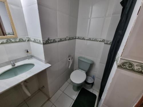 a small bathroom with a toilet and a sink at Pousada Zênit Peró II in Cabo Frio