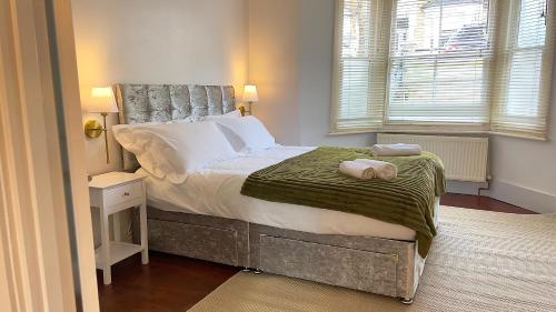 1 dormitorio con 1 cama con 2 toallas en London Townhouse 1-Bed Apartment with Garden in Tufnell Park near Emirates Stadium and 10 mins to Kings Cross en Londres