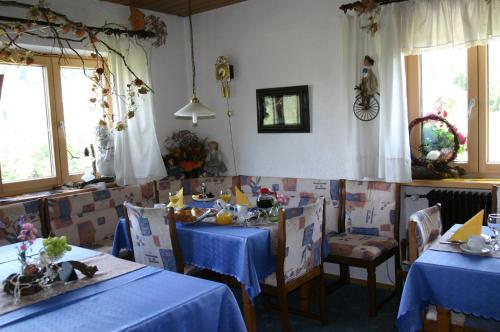 ein Esszimmer mit 2 Tischen und blauen Tischdecken in der Unterkunft Pension Hoisl in Schönberg