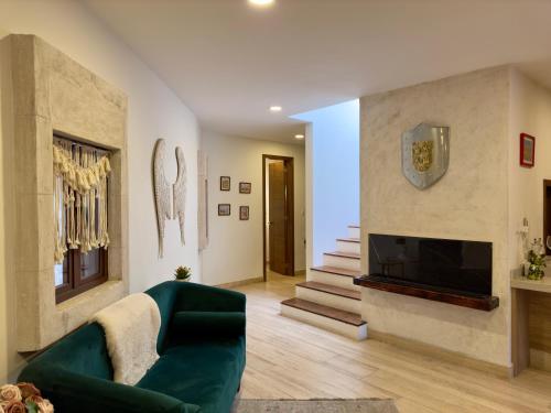 uma sala de estar com um sofá verde e uma lareira em Loft Spello en Val´Quirico em Santeagueda