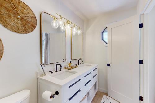 a white bathroom with a sink and a mirror at Cashmere Cottage in Cashiers