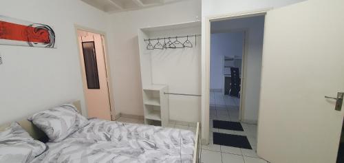 1 dormitorio con 1 cama y puerta que da a un pasillo en L'escapade des châteaux & beauval, en Montrichard