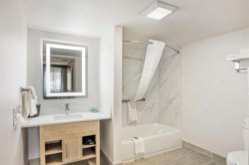uma casa de banho branca com um lavatório e uma banheira em Best Western Westgate Inn em York