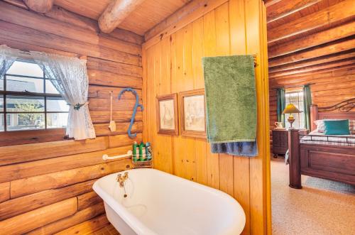 1 dormitorio y baño con bañera. en Waterfront Livingston Log Cabin with Private Dock!, en Blanchard