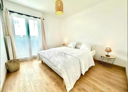 a white bedroom with a bed and a window at Magnifique appartement en face du stade Vélodrome in Marseille