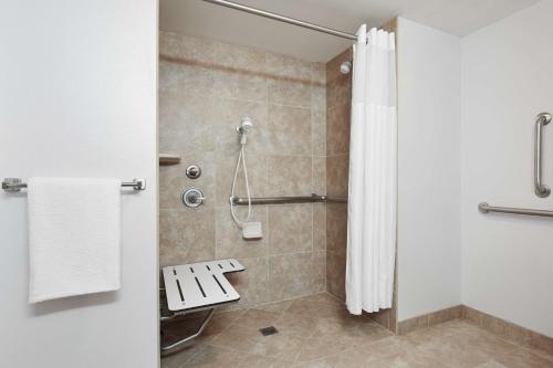 a bathroom with a shower with a bench in it at Hilton Garden Inn Columbus/Dublin in Dublin