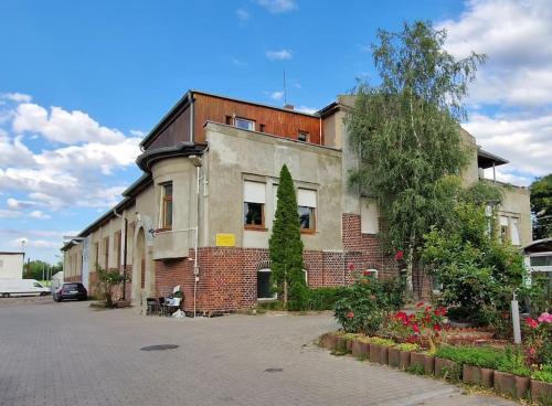 um velho edifício de tijolos com uma árvore em frente em Große, geräumige Unterkunft für bis zu 13 Personen! em Leipzig