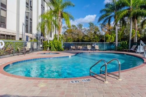 een zwembad met palmbomen en een gebouw bij Hampton Inn Sarasota I-75 Bee Ridge in Sarasota