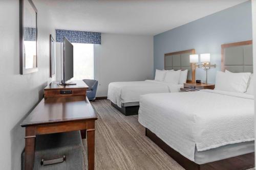 ein Hotelzimmer mit 2 Betten und einem TV in der Unterkunft Hampton Inn Sarasota I-75 Bee Ridge in Sarasota
