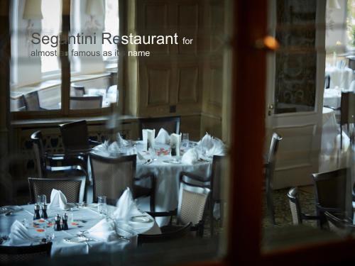 a dining room with tables and chairs with napkins on them at Hotel Schweizerhof St. Moritz in St. Moritz