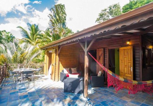 a house with a patio with a table and chairs at L'Îlot Palmiers in Pointe-Noire