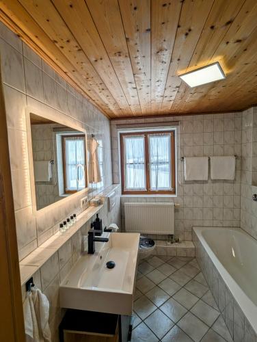 a bathroom with a tub and a sink and a bath tub at Ferienwohnung Alpenblick Dorner - VON MARTIN in Oberreute